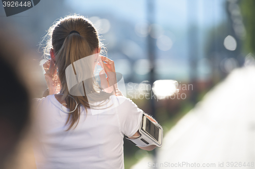 Image of jogging woman setting phone before jogging