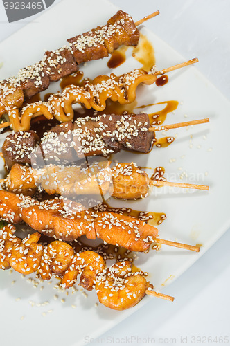 Image of Grilled juicy skewered shashlik on a plate, sesame