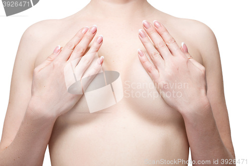 Image of Examining breasts. Close-up of young shirtless woman examining her breasts while. Isolated white background