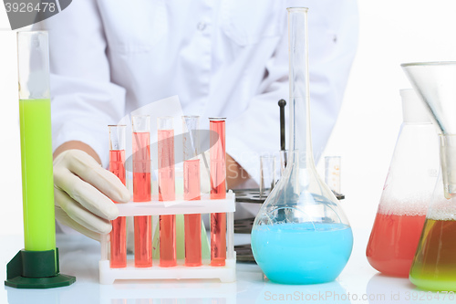 Image of hands holding test tubes with chemical elements. 