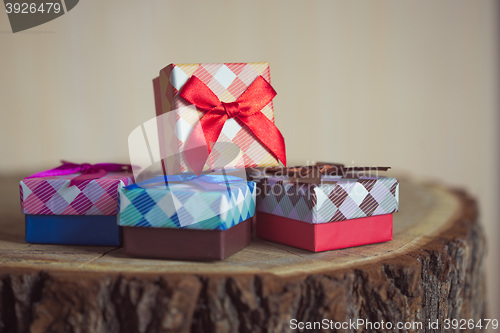 Image of Gift box with red bow on wood background