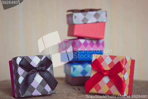 Image of Gift box with red and black bow on wood background