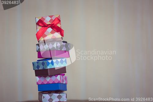 Image of Gift box with red bow on wood background