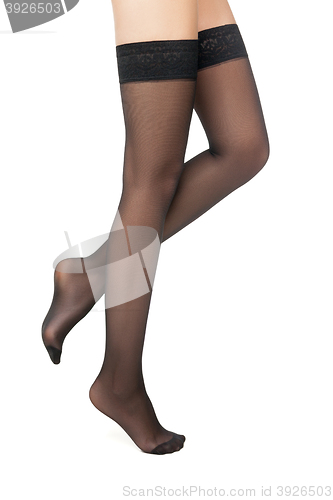 Image of Side view of woman standing in black stockings