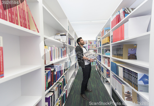 Image of Student holding lot of books in school library