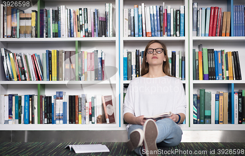 Image of female student study in library, using tablet and searching for 