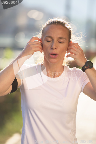 Image of jogging woman setting phone before jogging