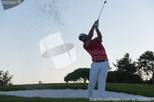 Image of golfer hitting a sand bunker shot on sunset