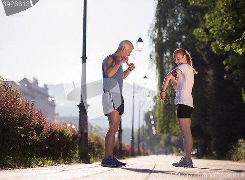 Image of jogging couple planning running route  and setting music