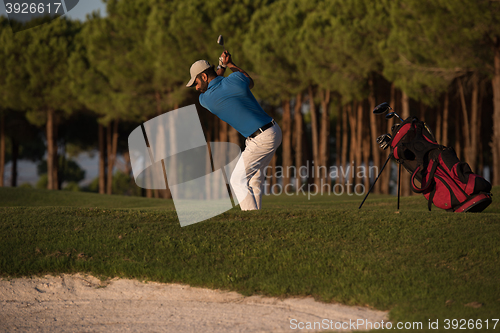 Image of golfer hitting a sand bunker shot on sunset