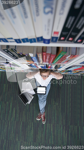 Image of female student study in library, using tablet and searching for 