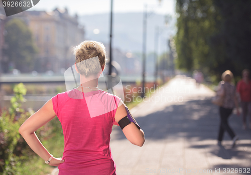 Image of jogging woman setting phone before jogging