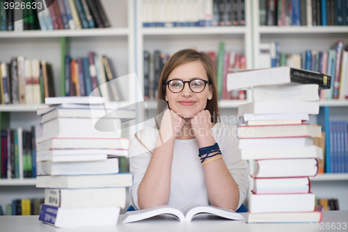 Image of female student study in library, using tablet and searching for 