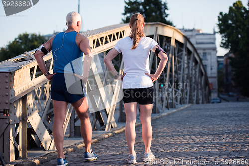 Image of jogging couple planning running route  and setting music