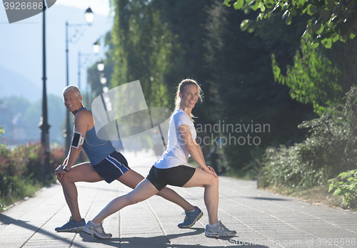 Image of couple warming up and stretching before jogging