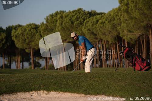 Image of golfer hitting a sand bunker shot on sunset