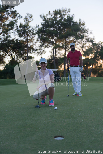 Image of couple on golf course at sunset