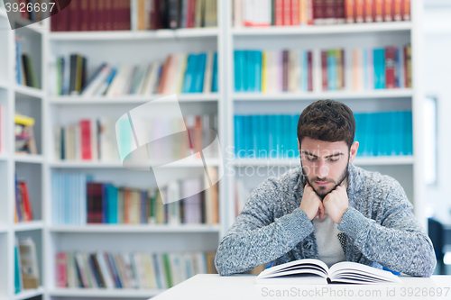 Image of portrait of student while reading book  in school library