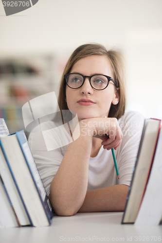 Image of portrait of famale student selecting book to read in library