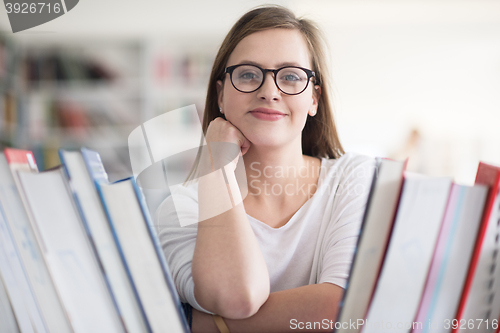 Image of portrait of famale student selecting book to read in library