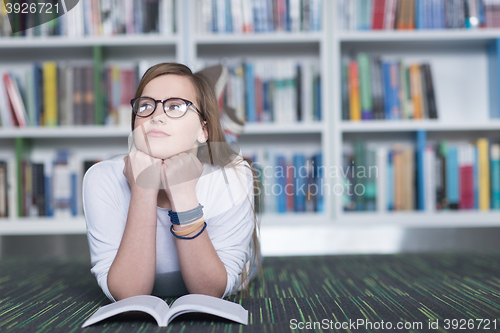 Image of female student study in library, using tablet and searching for 