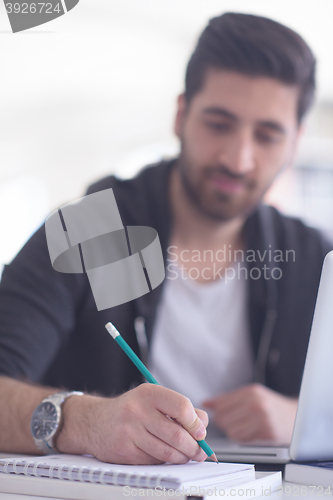 Image of student in school library using laptop for research