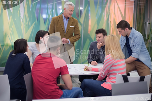 Image of teacher with a group of students in classroom