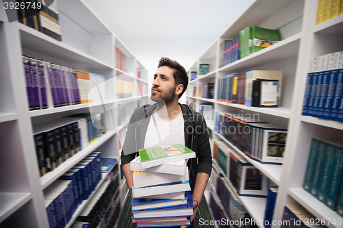 Image of Student holding lot of books in school library