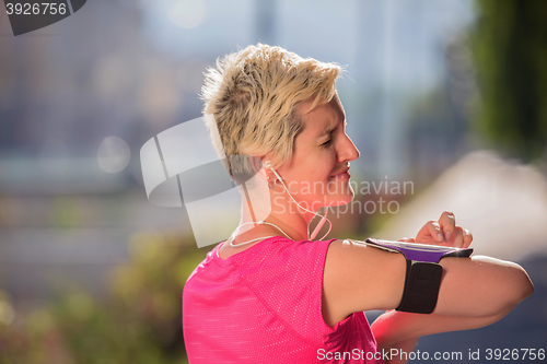 Image of jogging woman setting phone before jogging