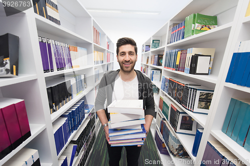 Image of Student holding lot of books in school library