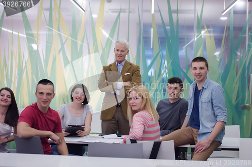 Image of portrait of  teacher with students group in background