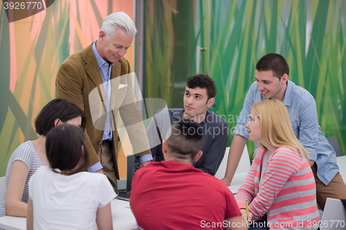 Image of teacher with a group of students in classroom