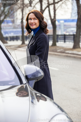 Image of woman in a dark coat near car