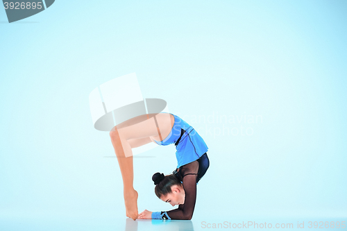 Image of The girl doing gymnastics dance on a blue background