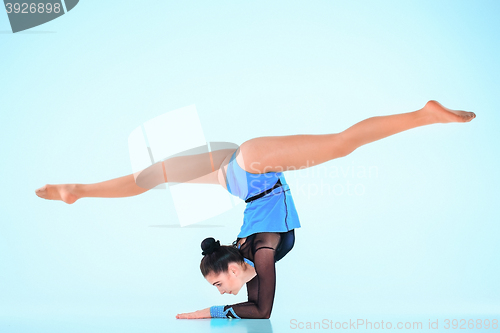 Image of The girl doing gymnastics dance on a blue background