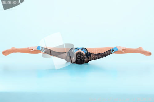 Image of The girl doing gymnastics dance on a blue background