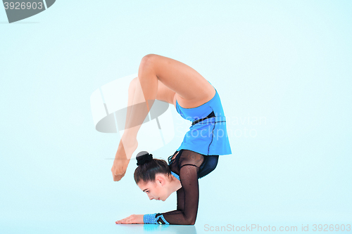 Image of The girl doing gymnastics dance on a blue background