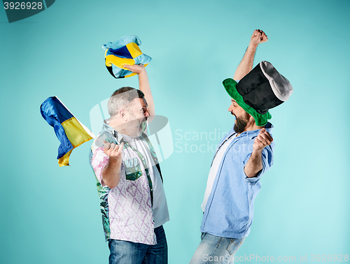 Image of The two football fans with a flag of Ukraine over blue