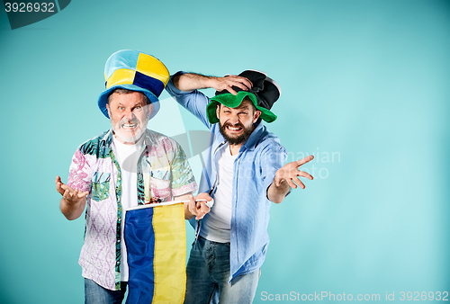 Image of The two football fans with a flag of Ukraine over blue