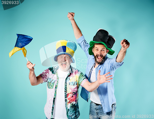 Image of The two football fans with a flag of Ukraine over blue