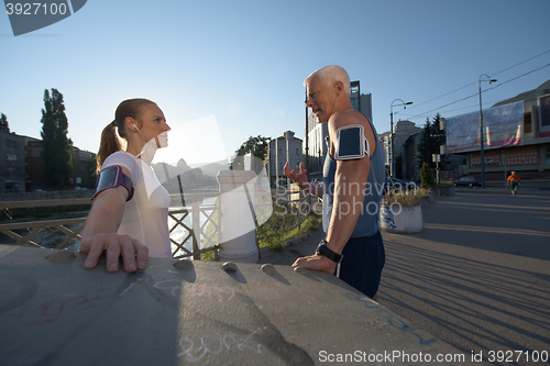 Image of jogging couple planning running route  and setting music