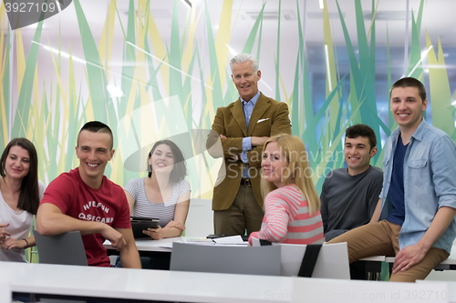 Image of portrait of  teacher with students group in background