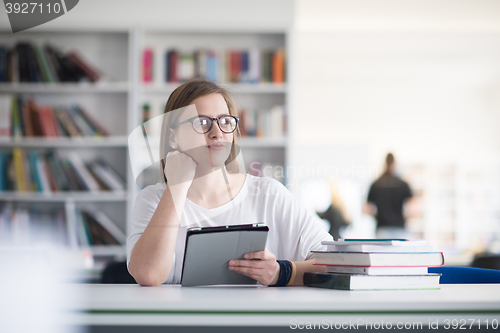 Image of female student study in school library, using tablet