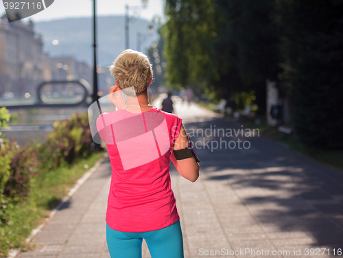 Image of jogging woman setting phone before jogging