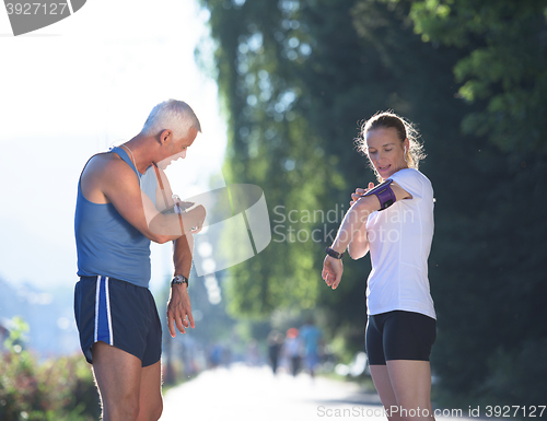 Image of jogging couple planning running route  and setting music