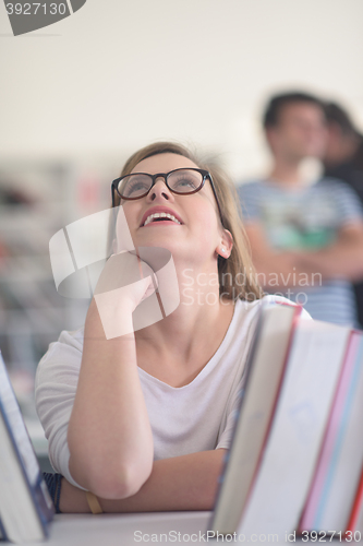 Image of portrait of famale student selecting book to read in library