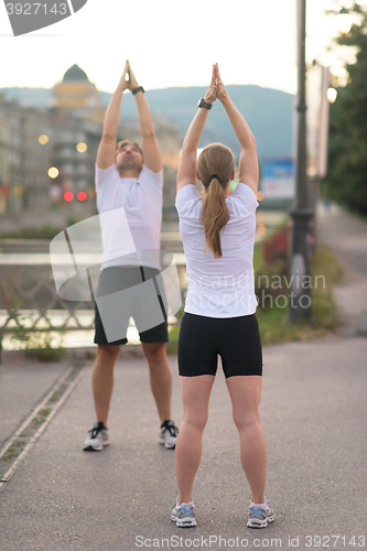 Image of couple warming up before jogging