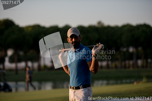 Image of golfer  portrait at golf course on sunset