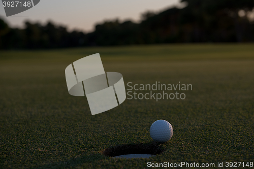 Image of golf ball on edge of  the hole