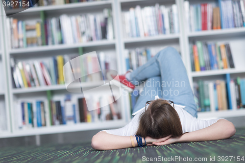 Image of female student study in library, using tablet and searching for 